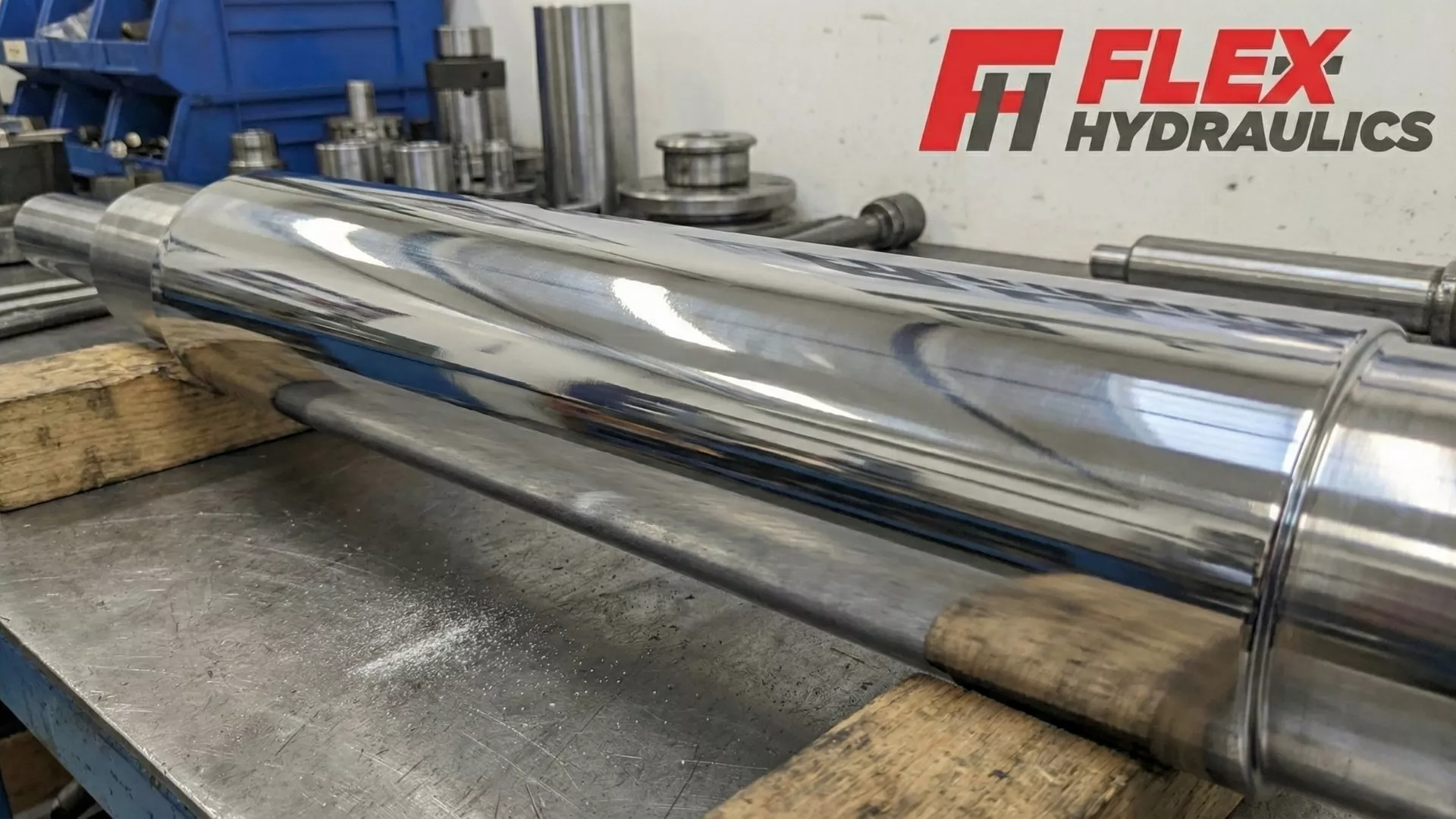A close-up view of a highly polished, silver hydraulic cylinder rod that has just undergone hard chroming hydraulic cylinders process, reflecting the workshop lights.